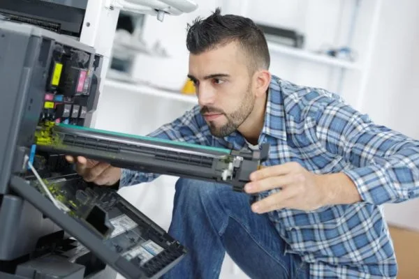Un technicien de RLS intervient sur un photocopieur